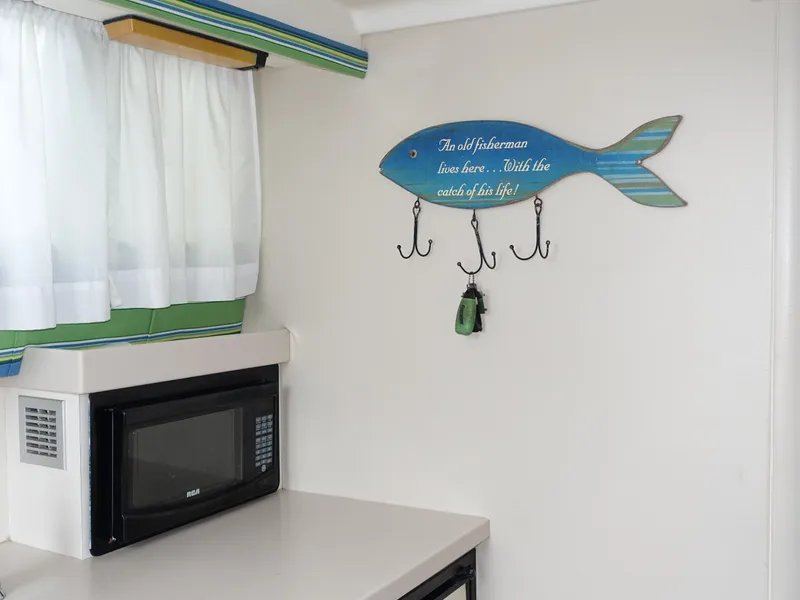 Slide: The Image of Kitchen area in 1998 Mainship 31 Sedan Bridge with fish-shaped wall hooks. - 14