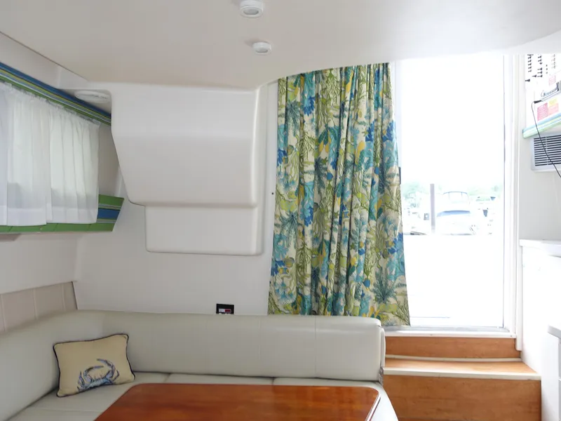 Slide: The Image of Interior of 1998 Mainship 31 Sedan Bridge with floral curtains and cushioned seating. - 18