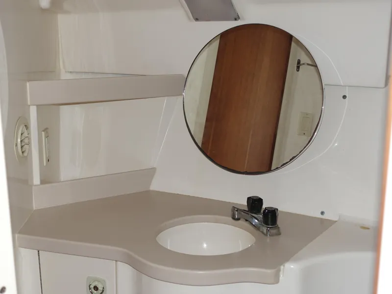 Slide: The Image of 1998 Mainship 31 Sedan Bridge bathroom with round mirror and sink. - 19