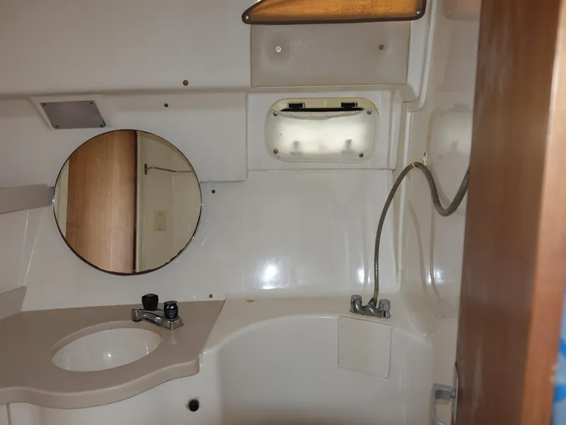 Slide: The Image of 1998 Mainship 31 Sedan Bridge bathroom with sink, mirror, and showerhead. - 20