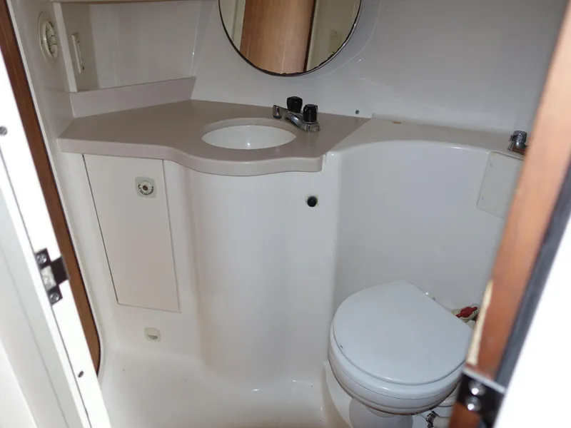 Slide: The Image of 1998 Mainship 31 Sedan Bridge bathroom with sink, toilet, and mirror. - 21