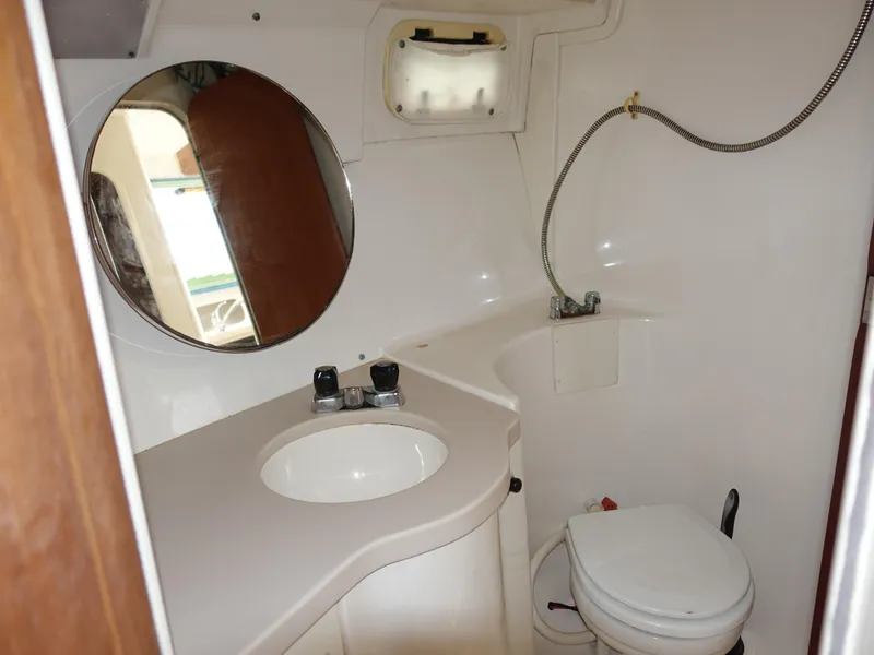 Slide: The Image of 1998 Mainship 31 Sedan Bridge bathroom with sink, mirror, and toilet. - 22