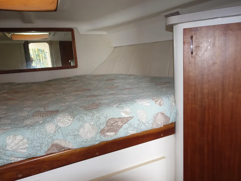 Slide: The Image of 1998 Mainship 31 Sedan Bridge cabin interior with bed and wooden cabinet. - 27