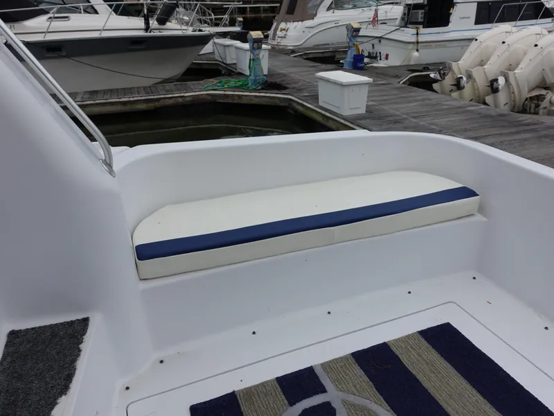 Slide: The Image of 1998 Mainship 31 Sedan Bridge boat with cushioned seating on deck, docked at marina. - 30