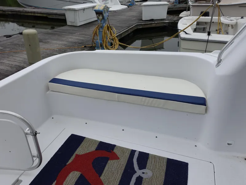 Slide: The Image of 1998 Mainship 31 Sedan Bridge boat deck with cushioned seating and nautical-themed rug. - 31