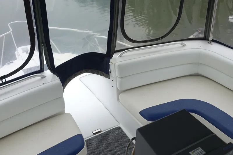 Slide: The Image of 1998 Mainship 31 Sedan Bridge interior with white seating and blue accents. - 4