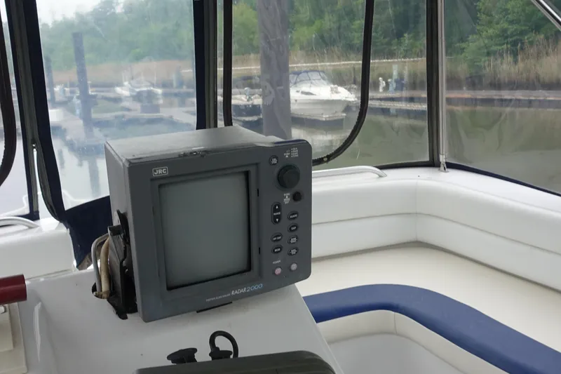 Slide: The Image of 1998 Mainship 31 Sedan Bridge interior with navigation equipment, docked at marina. - 5