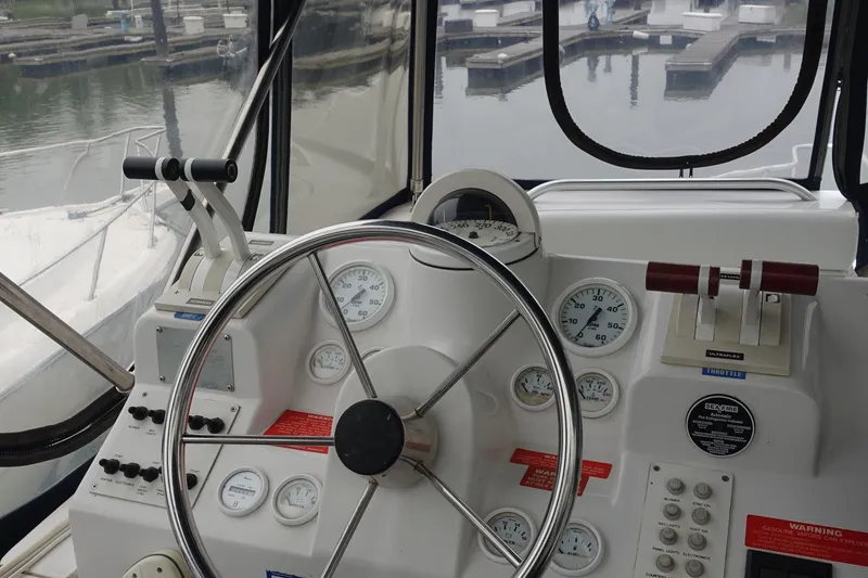 Slide: The Image of 1998 Mainship 31 Sedan Bridge helm with steering wheel and gauges, dock view. - 6