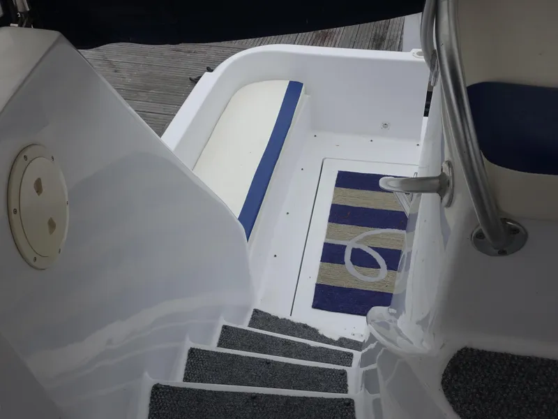 Slide: The Image of 1998 Mainship 31 Sedan Bridge interior with stairs and nautical-themed mat. - 9