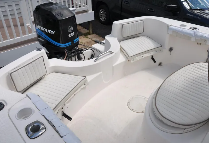 Slide: The Image of 2003 Trophy 1903 Center Console boat interior with Mercury 125 engine, featuring white cushioned seating. - 11