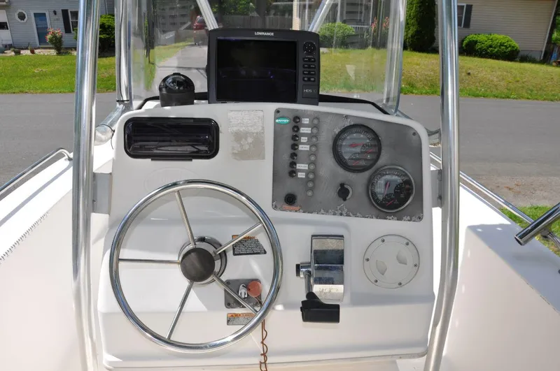Slide: The Image of Center console of a 2003 Trophy 1903 boat with steering wheel and gauges. - 13