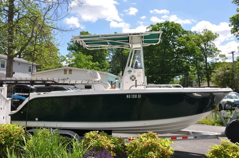 Slide: The Image of 2003 Trophy 1903 Center Console boat on trailer, surrounded by greenery. - 2