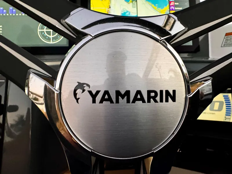 Slide: The Image of Steering wheel of 2023 Yamarin 88 DC boat with logo prominently displayed. - 14