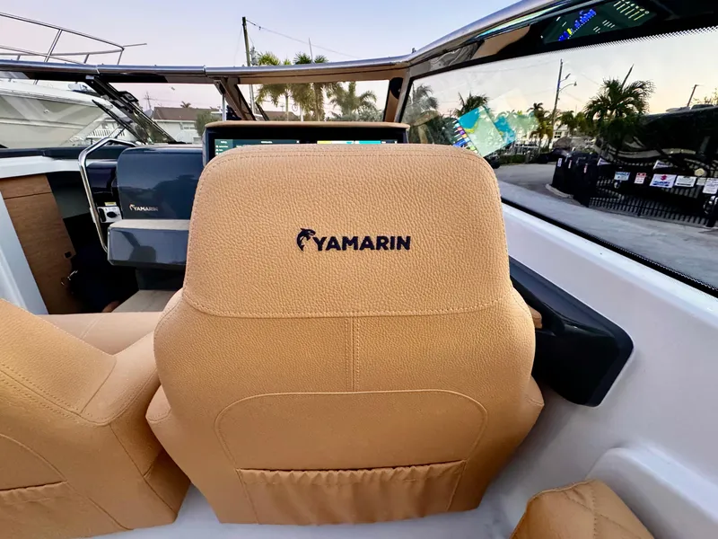 Slide: The Image of Yamarin 88 DC 2023 boat interior with tan seats and dashboard view. - 16