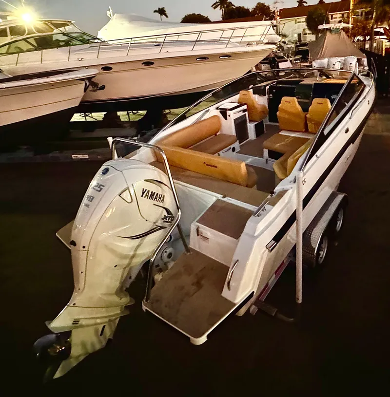 Slide: The Image of 2023 Yamarin 88 DC boat with Yamaha engine, docked at marina during evening. - 2