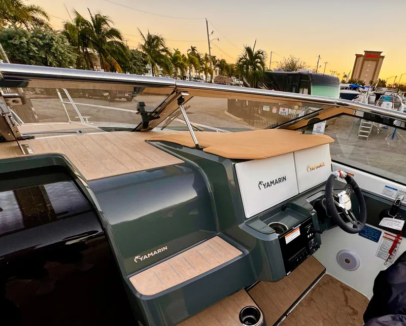 Slide: The Image of 2023 Yamarin 88 DC boat dashboard with steering wheel, docked at sunset. - 28