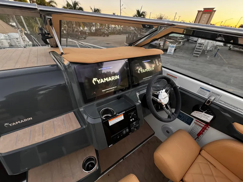 Slide: The Image of 2023 Yamarin 88 DC boat dashboard with dual screens and tan leather seating. - 36