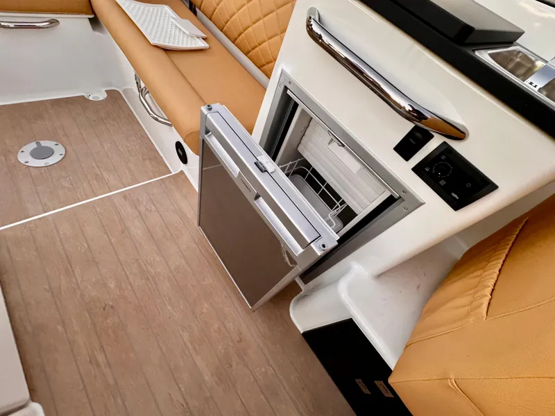 Slide: The Image of 2023 Yamarin 88 DC boat interior with open fridge and tan seating. - 6