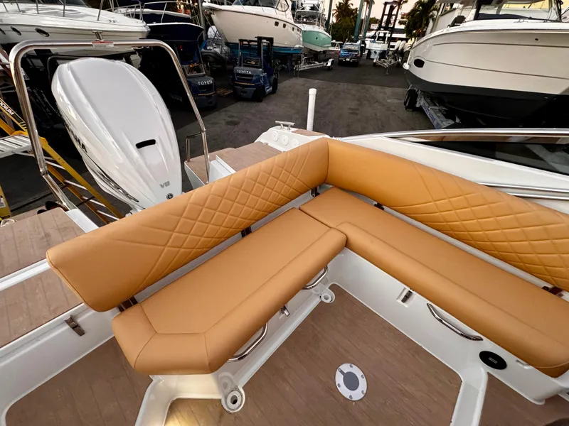 Slide: The Image of 2023 Yamarin 88 DC boat with tan leather seating in a marina setting. - 9