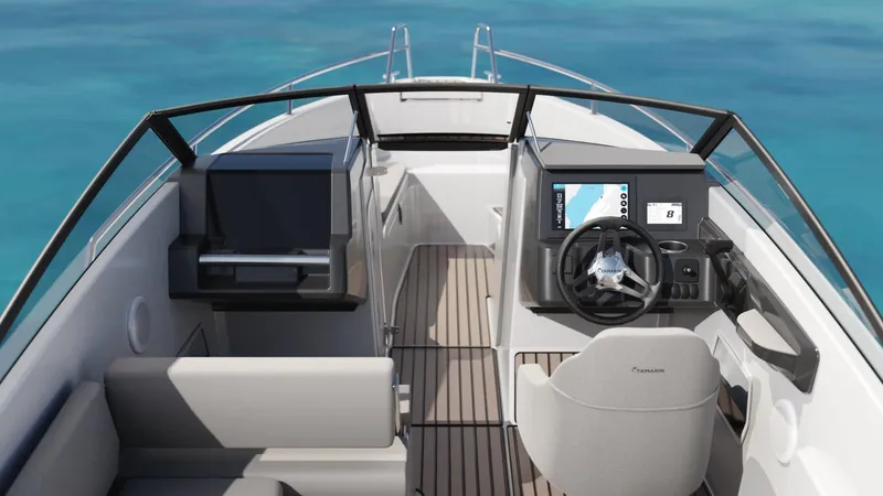 Slide: The Image of 2026 Yamarin 63 boat interior with modern dashboard and seating, on clear blue water. - 3