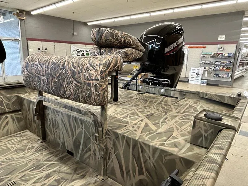 Slide: The Image of 2025 Lowe RX1860 CC boat with camo seats and Mercury outboard motor in showroom. - 3