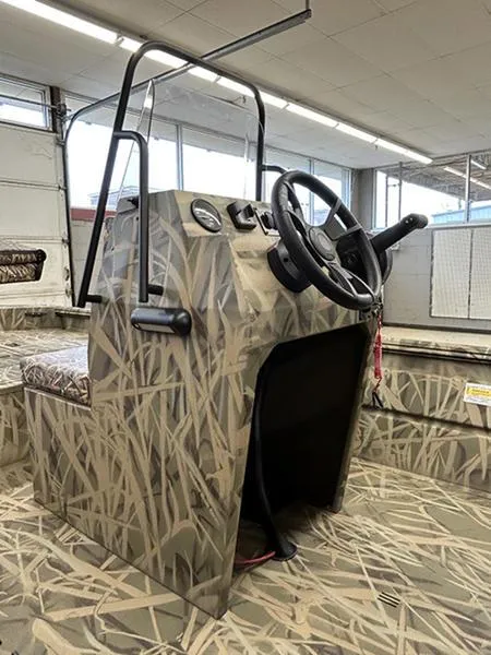 Slide: The Image of 2025 Lowe RX1860 CC boat console with camouflage design in a showroom. - 4