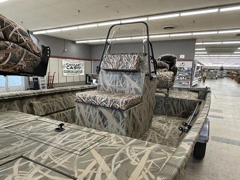 Slide: The Image of 2025 Lowe RX1860 CC boat with camouflage seating in a showroom. - 5