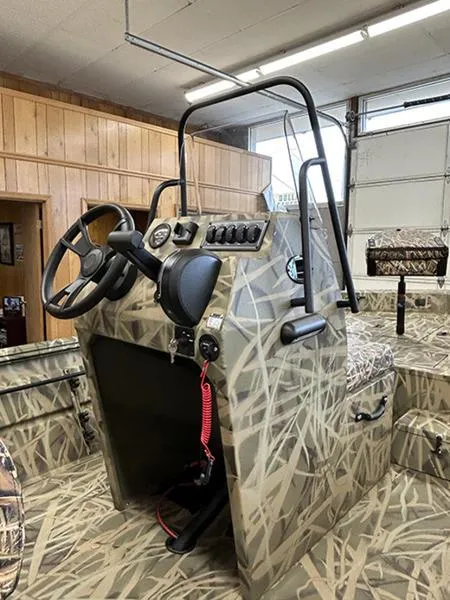 Slide: The Image of 2025 Lowe RX1860 CC boat interior with camouflage design and steering console. - 6