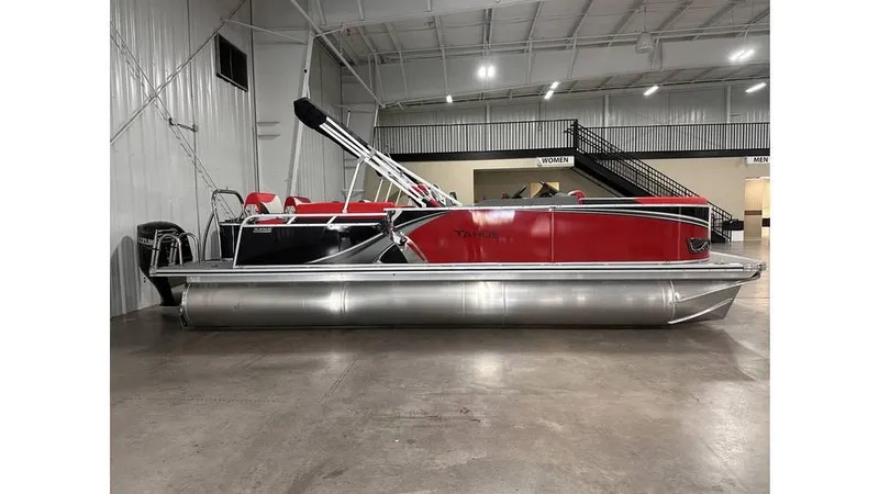 Slide: The Image of 2025 Tahoe Pontoon LTZ Quad Lounger Shift in showroom, featuring sleek red and silver design. - 1