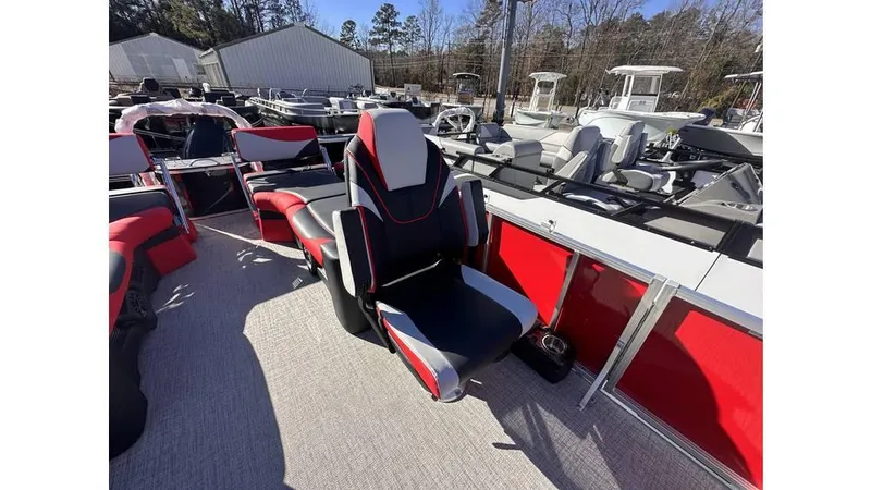 Slide: The Image of 2025 Tahoe Pontoon LTZ Quad Lounger Shift with red and black seating, docked outdoors. - 5
