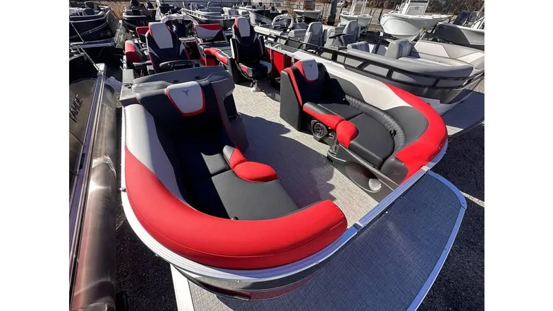 Slide: The Image of 2025 Tahoe Pontoon LTZ Quad Lounger Shift with red and black seating, docked among other boats. - 7