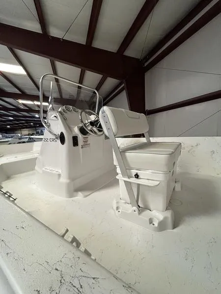 Slide: The Image of 2024 ALK2 Powerboats 22 CRS interior with steering console and seating in a warehouse. - 3