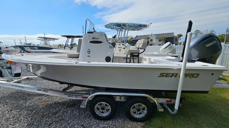 Slide: The Image of 2024 Sea Pro 210 Bay boat on trailer, side view, with Yamaha outboard motor. - 1