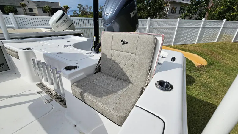 Slide: The Image of 2024 Sea Pro 210 Bay boat interior with cushioned seating and rod holders. - 14