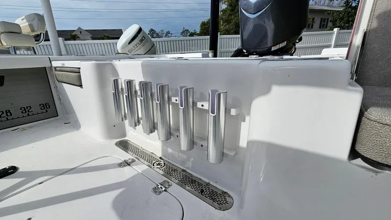 Slide: The Image of 2024 Sea Pro 210 Bay boat with rod holders and engine in the background. - 18