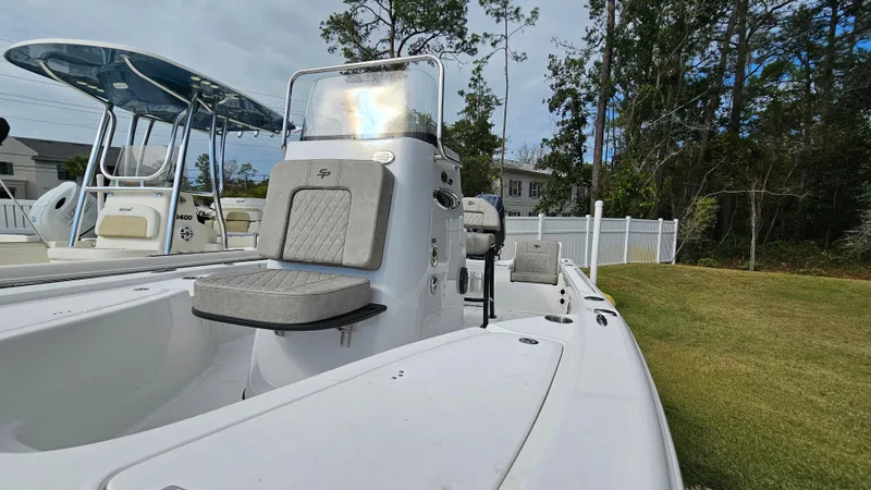 Slide: The Image of 2024 Sea Pro 210 Bay boat, white exterior, parked on grass near trees and a fence. - 20
