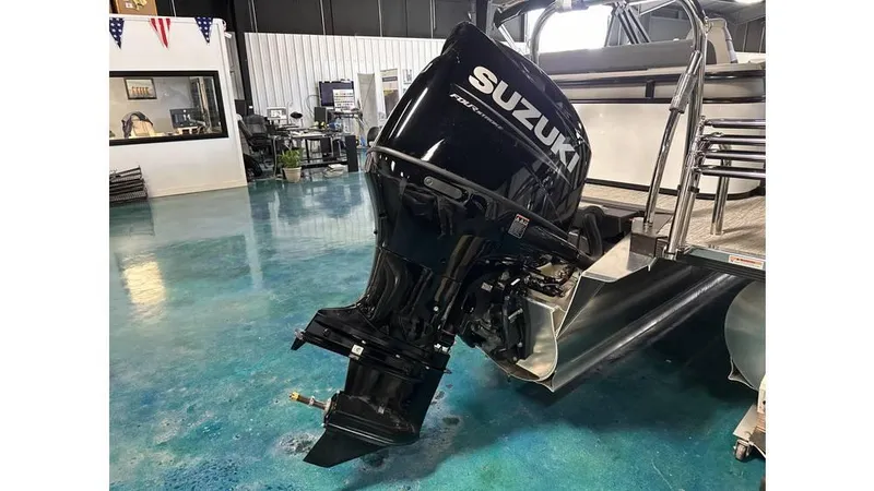 Slide: The Image of 2025 Tahoe Pontoon LTZ Versatile Rear Lounger with Suzuki outboard motor in showroom. - 10