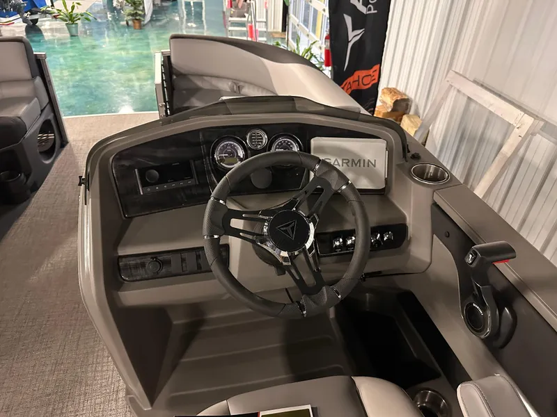 Slide: The Image of 2025 Tahoe Pontoon LTZ Cruise Rear Bench dashboard with steering wheel and Garmin display. - 2
