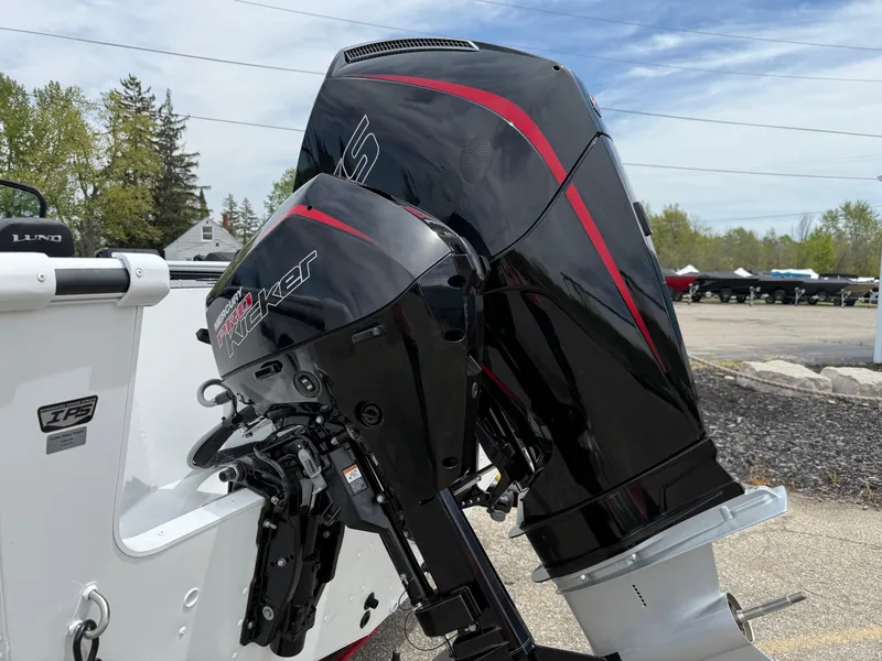 Slide: The Image of 2025 Lund Fisherman 2075 boat with Mercury Kicker outboard motor, parked outdoors. - 3