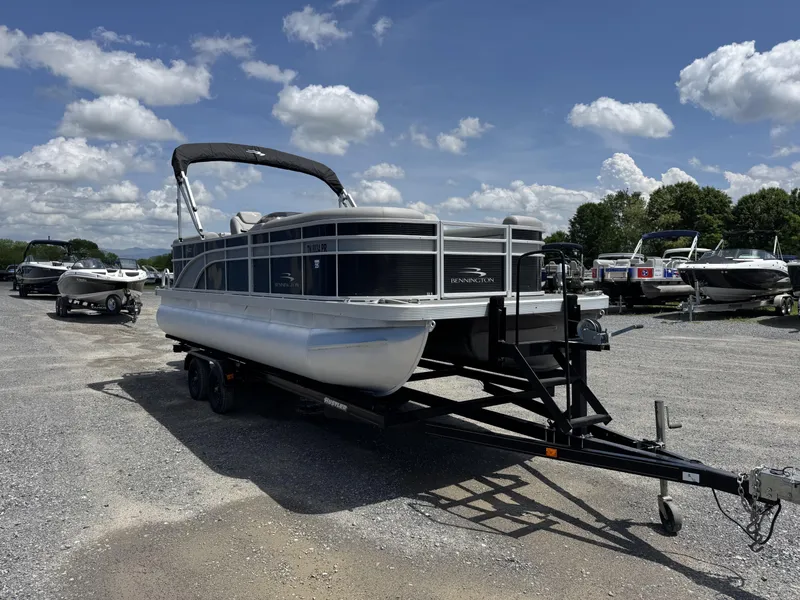 Slide: The Image of 2022 Bennington 22 SSR pontoon boat on trailer under a blue sky with clouds. - 11