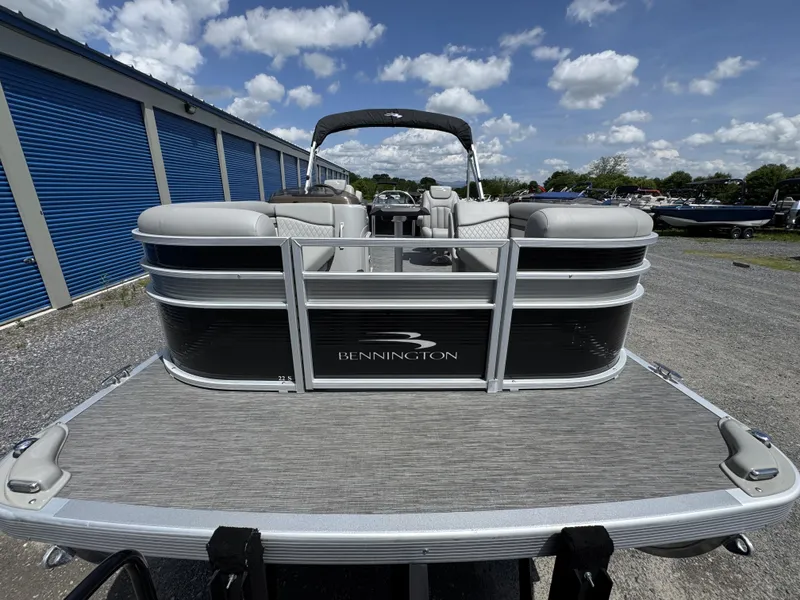 Slide: The Image of 2022 Bennington 22 SSR pontoon boat parked outdoors under a blue sky. - 12