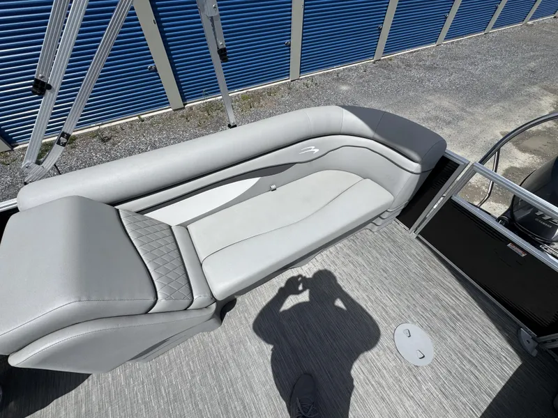 Slide: The Image of 2022 Bennington 22 SSR boat interior with gray seating and blue storage units in background. - 18