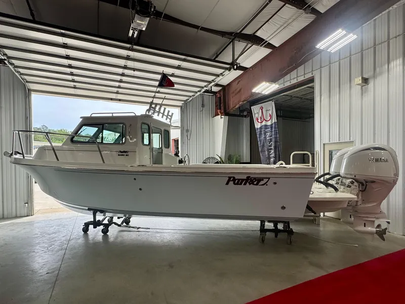 Slide: The Image of 2025 Parker 2420 Sport Cabin boat in a warehouse, side view. - 1