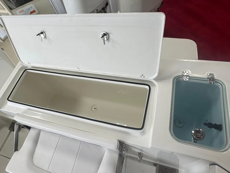 Slide: The Image of 2025 Parker 2420 Sport Cabin boat interior with open storage compartments. - 10