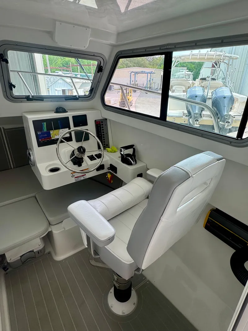 Slide: The Image of 2025 Parker 2420 Sport Cabin interior with modern helm and comfortable seating. - 12