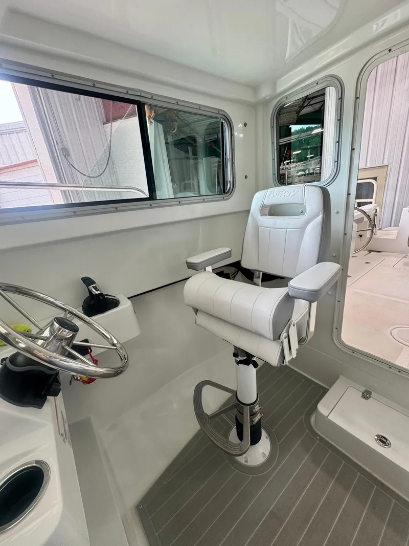 Slide: The Image of 2025 Parker 2420 Sport Cabin interior with modern helm seat and steering wheel. - 15