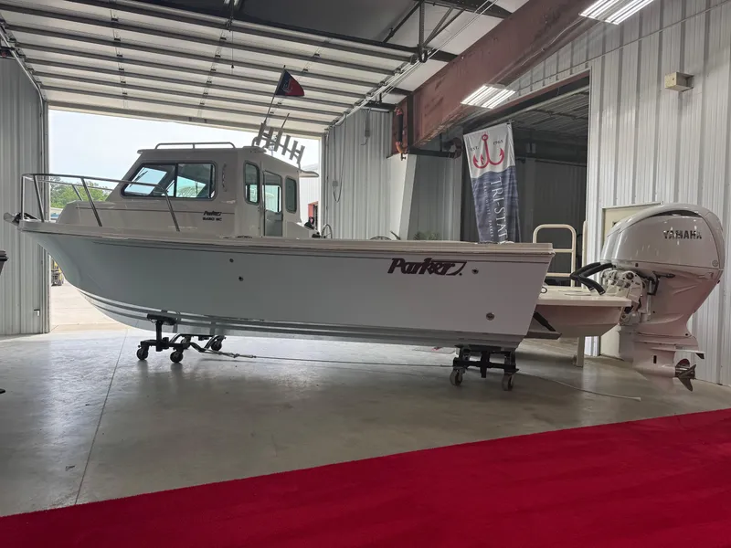 Slide: The Image of 2025 Parker 2420 Sport Cabin boat in a showroom with Yamaha engine. - 3