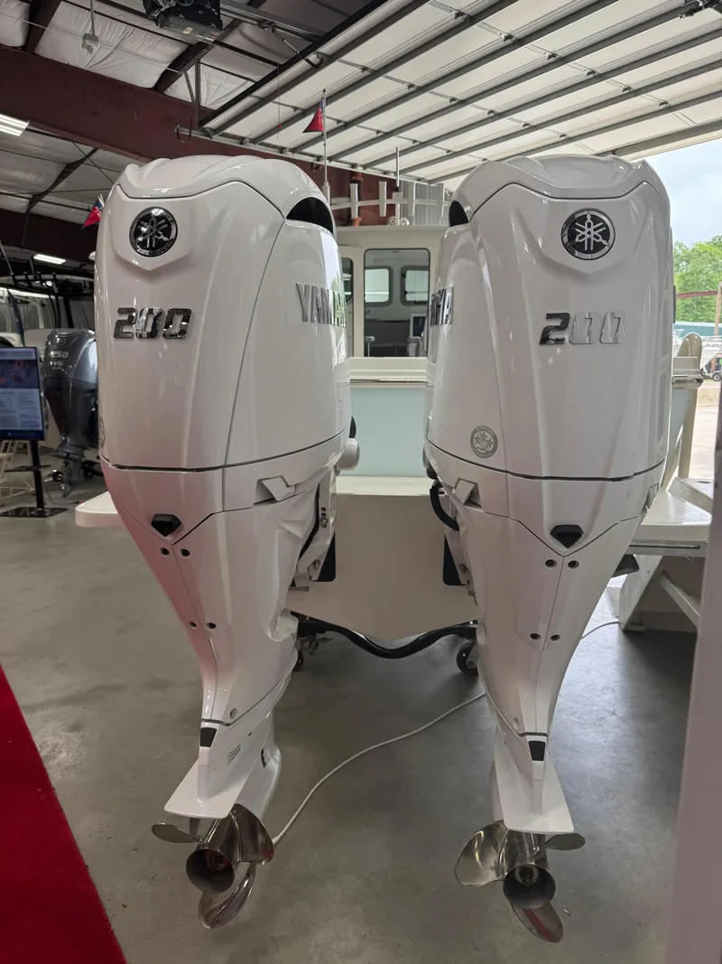 Slide: The Image of 2025 Parker 2420 Sport Cabin with dual Yamaha 200 outboard engines in a showroom. - 4