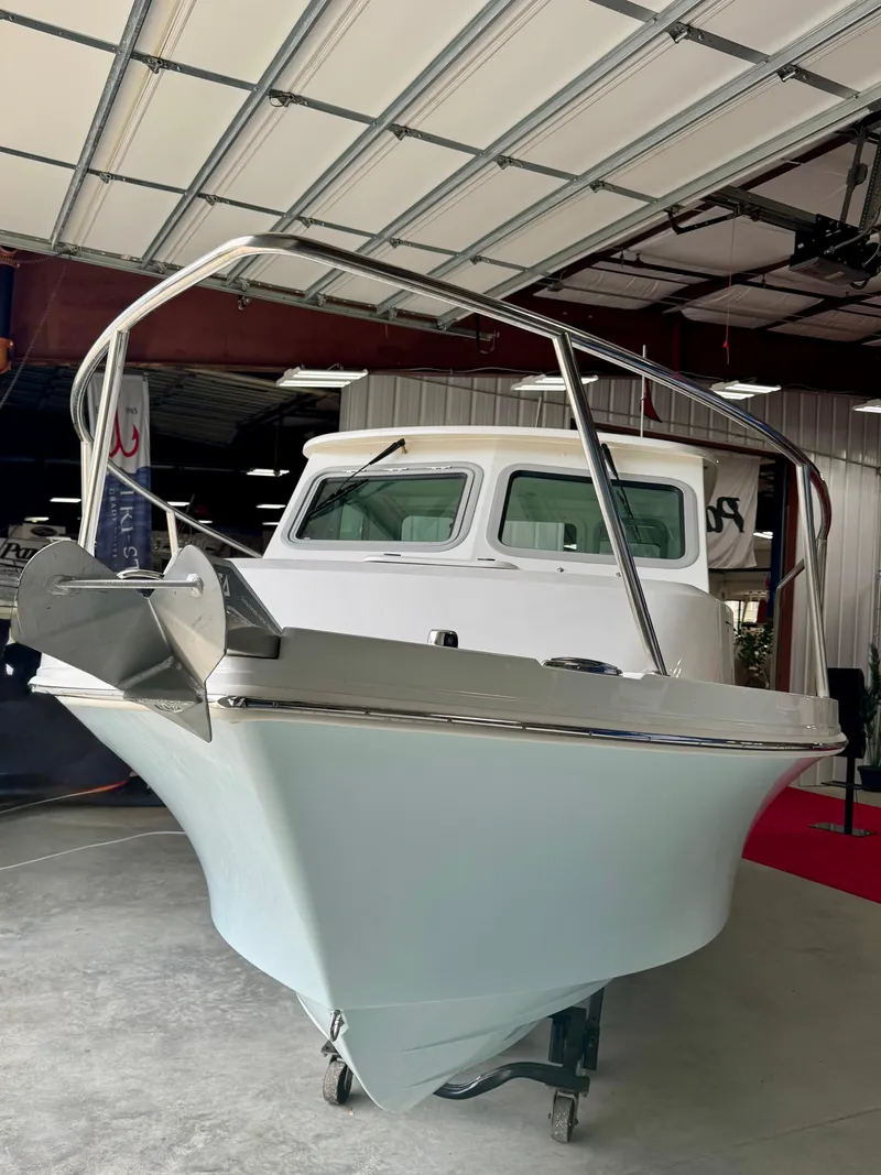 Slide: The Image of 2025 Parker 2420 Sport Cabin boat in a showroom, showcasing sleek design and modern features. - 5