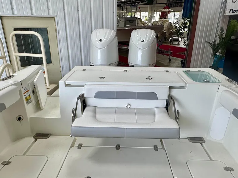 Slide: The Image of 2025 Parker 2420 Sport Cabin boat interior with seating and dual outboard motors. - 8